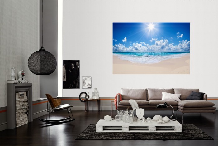Die Fototapete Sandstrand im Sonnenschein als Wandbild im Wohnzimmer. Die Vlies-Fototapete Sandstrand im Sonnenschein verschönert als Wandbild Deine Wand.