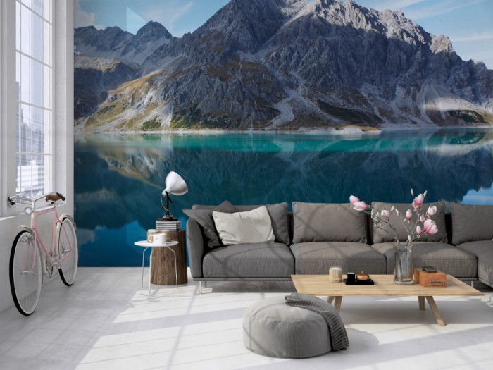 Die Fototapete Einsamer Bergsee in den Alpen auf einer großen Wand im Loft tapeziert. Die Fototapete Einsamer Bergsee in den Alpen wird individuell auf Deine Wand angepasst.