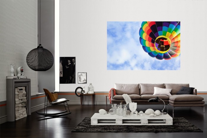 Die Fototapete Heissluftballon im Himmel als Wandbild im Wohnzimmer. Die Vlies-Fototapete Heissluftballon im Himmel verschönert als Wandbild Deine Wand.