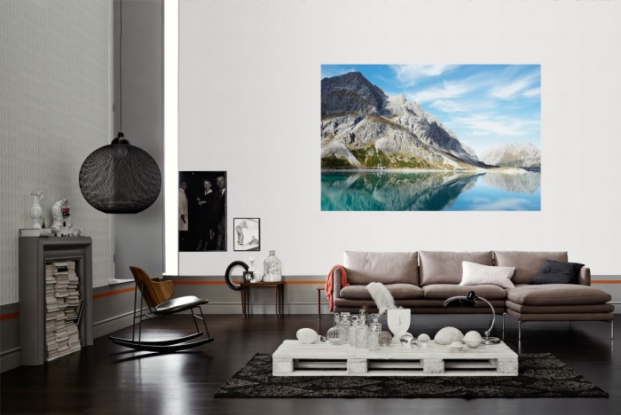 Die Fototapete Stiller Bergsee in den Alpen als Wandbild im Wohnzimmer. Die Vlies-Fototapete Stiller Bergsee in den Alpen verschönert als Wandbild Deine Wand.