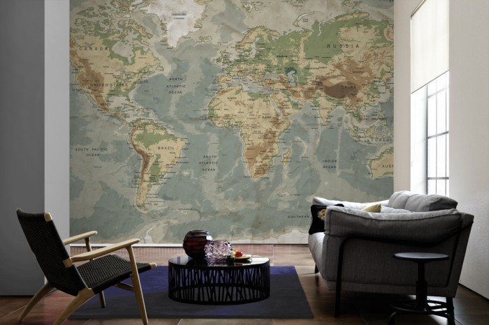 Im Wohnzimmer die Fototapete Weltkarte, physische Landkarte auf einer großen Wand tapeziert. Die Fototapete Weltkarte, physische Landkarte ist als Vlies-Fototapete im Wohnzimmer leicht zu tapezieren.