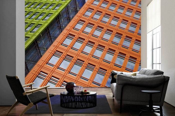 Im Wohnzimmer die Fototapete Wolkenkratzer Fassaden auf einer großen Wand tapeziert. Die Fototapete Wolkenkratzer Fassaden ist als Vlies-Fototapete im Wohnzimmer leicht zu tapezieren.