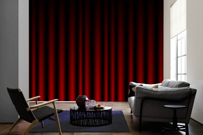 Im Wohnzimmer die Fototapete Roter Vorhang, Kinovorhang auf einer großen Wand tapeziert. Die Fototapete Roter Vorhang, Kinovorhang ist als Vlies-Fototapete im Wohnzimmer leicht zu tapezieren.