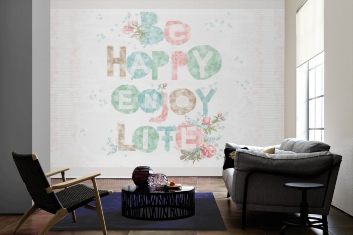Im Wohnzimmer die Design-Fototapete Djooz Aquarell Schrift, Be Happy Enjoy Life auf einer großen Wand tapeziert. Die Design-Fototapete Djooz Aquarell Schrift, Be Happy Enjoy Life ist als Vlies-Fototapete im Wohnzimmer leicht zu tapezieren.