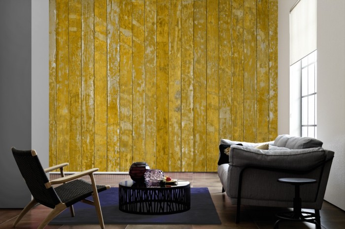 Im Wohnzimmer die Fototapete Holz Wand, alte Holzdielen in gelb auf einer großen Wand tapeziert. Die Fototapete Holz Wand, alte Holzdielen in gelb ist als Vlies-Fototapete im Wohnzimmer leicht zu tapezieren.