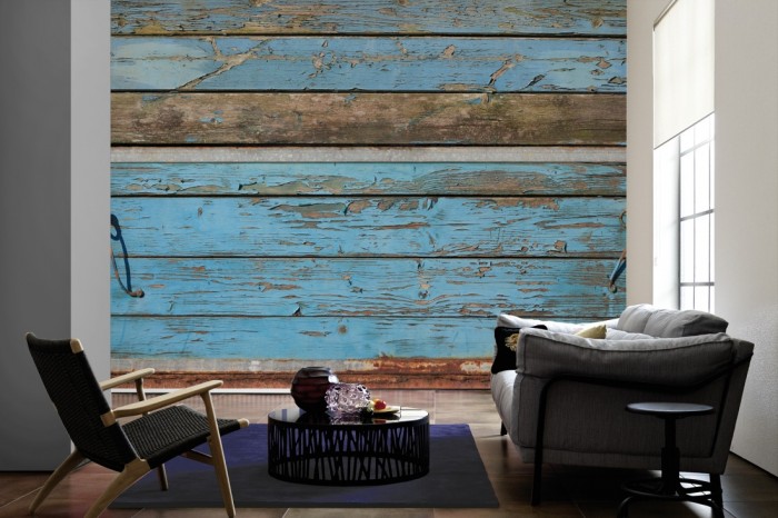 Im Wohnzimmer die Fototapete Holz Wand, blaue Holzbretter auf einer großen Wand tapeziert. Die Fototapete Holz Wand, blaue Holzbretter ist als Vlies-Fototapete im Wohnzimmer leicht zu tapezieren.