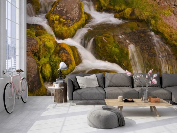 Die Fototapete Wasserfall im Gebirge auf einer großen Wand im Loft tapeziert. Die Fototapete Wasserfall im Gebirge wird individuell auf Deine Wand angepasst.