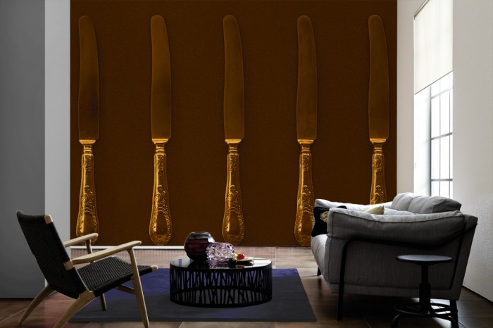 Im Wohnzimmer die Fototapete Messer aus Gold auf einer großen Wand tapeziert. Die Fototapete Messer aus Gold ist als Vlies-Fototapete im Wohnzimmer leicht zu tapezieren.