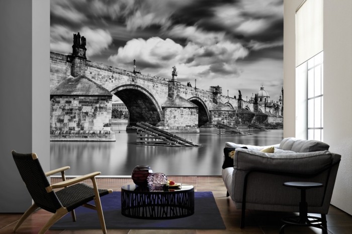 Im Wohnzimmer die Fototapete Karlsbrücke in Prag, schwarz-weiß auf einer großen Wand tapeziert. Die Fototapete Karlsbrücke in Prag, schwarz-weiß ist als Vlies-Fototapete im Wohnzimmer leicht zu tapezieren.