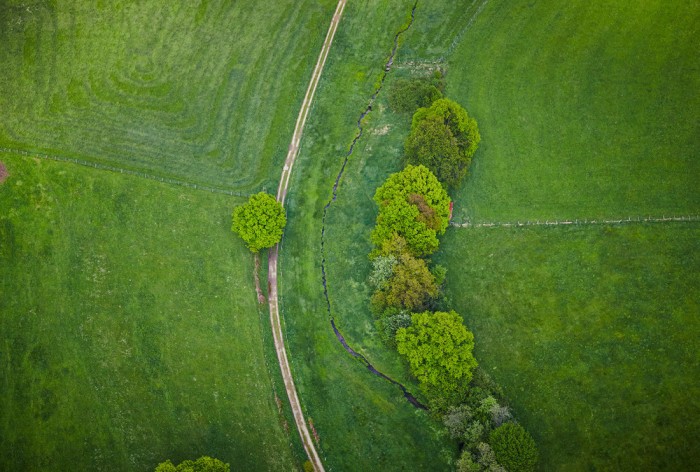Die Fototapete Luftbild, Grüne Landschaft von oben, eine Vlies-Fototapete bei Livingwalls Cologne online kaufen. Die Fototapete Luftbild, Grüne Landschaft von oben ist eine Fototapete auf Maß.