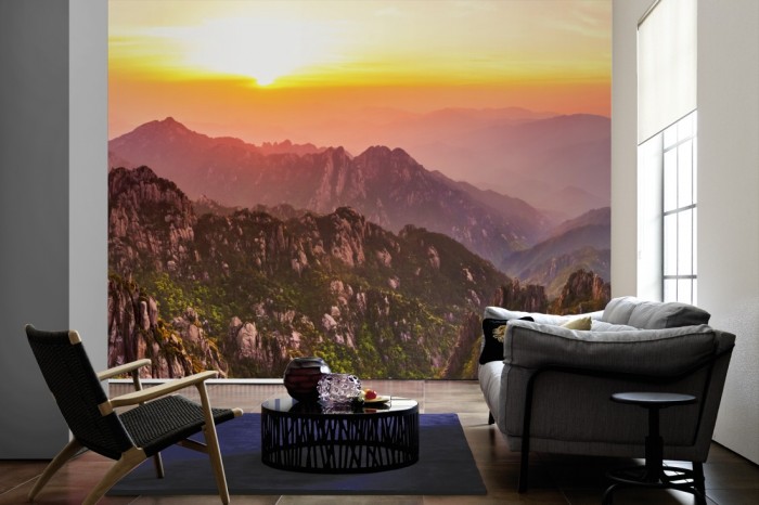 Im Wohnzimmer die Fototapete Berge im Sonnenuntergang, Huangshan Mountains auf einer großen Wand tapeziert. Die Fototapete Berge im Sonnenuntergang, Huangshan Mountains ist als Vlies-Fototapete im Wohnzimmer leicht zu tapezieren.