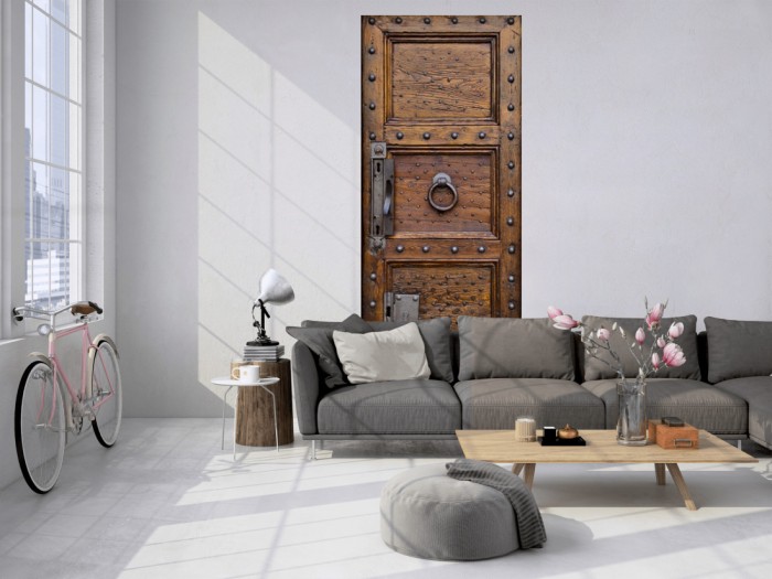 Das 3D Fotopanel Alte Holztür aus Eiche mit Nieten tapeziert in einem Loft. Bestelle die Bildtapete für Deine Wand online.