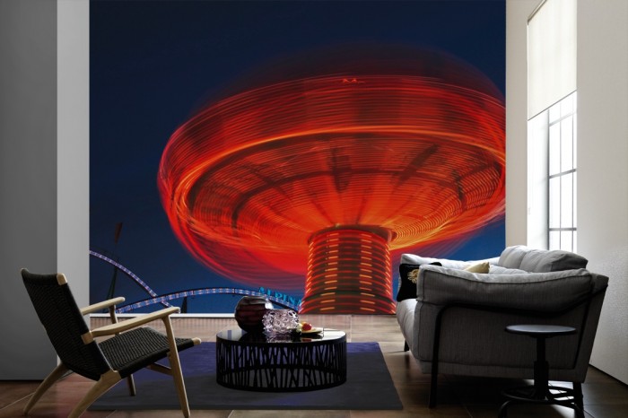 Im Wohnzimmer die Fototapete Karussell in Bewegung, Oktoberfest in München auf einer großen Wand tapeziert. Die Fototapete Karussell in Bewegung, Oktoberfest in München ist als Vlies-Fototapete im Wohnzimmer leicht zu tapezieren.