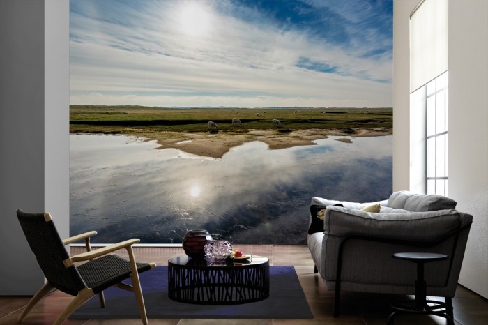Im Wohnzimmer die Fototapete Landschaft mit Schafen im Sonnenschein auf einer großen Wand tapeziert. Die Fototapete Landschaft mit Schafen im Sonnenschein ist als Vlies-Fototapete im Wohnzimmer leicht zu tapezieren.