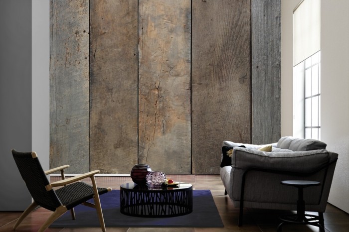 Im Wohnzimmer die Fototapete Holz Wand, vergraute Eiche auf einer großen Wand tapeziert. Die Fototapete Holz Wand, vergraute Eiche ist als Vlies-Fototapete im Wohnzimmer leicht zu tapezieren.