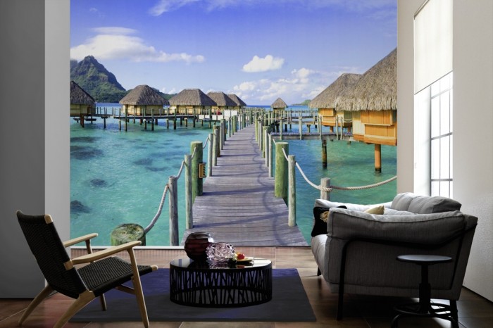 Im Wohnzimmer die Fototapete Tahiti, Häuser im Meer auf einer großen Wand tapeziert. Die Fototapete Tahiti, Häuser im Meer ist als Vlies-Fototapete im Wohnzimmer leicht zu tapezieren.
