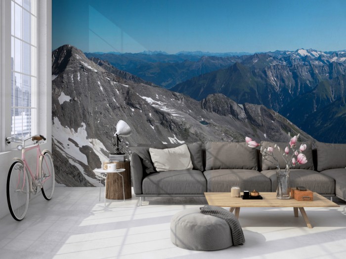 Die Fototapete Alpen Österreich, Panorama der Berge auf einer großen Wand im Loft tapeziert. Die Fototapete Alpen Österreich, Panorama der Berge wird individuell auf Deine Wand angepasst.