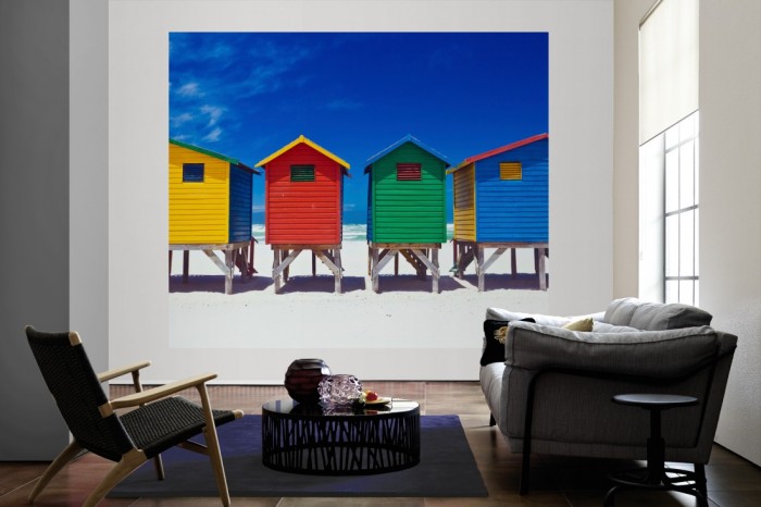 Die Fototapete Bunte Strandhäuser in Südafrika, Muizenberg als große Bildtapete im Wohnzimmer. Als Bildtapete ist die Fototapete Bunte Strandhäuser in Südafrika, Muizenberg ein besonderes Highlight auf Vliestapete.