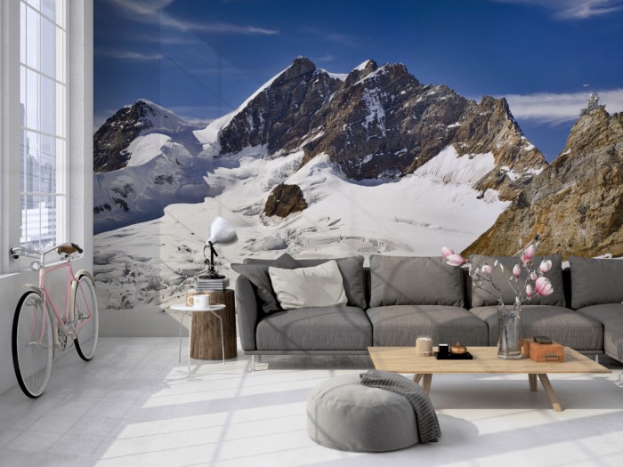 Die Fototapete Bergspitze im Schnee, Jungfraujoch Schweiz auf einer großen Wand im Loft tapeziert. Die Fototapete Bergspitze im Schnee, Jungfraujoch Schweiz wird individuell auf Deine Wand angepasst.