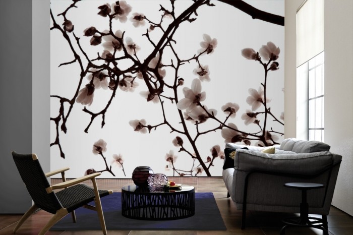 Im Wohnzimmer die Fototapete Magnolie Äste in Weiß auf einer großen Wand tapeziert. Die Fototapete Magnolie Äste in Weiß ist als Vlies-Fototapete im Wohnzimmer leicht zu tapezieren.