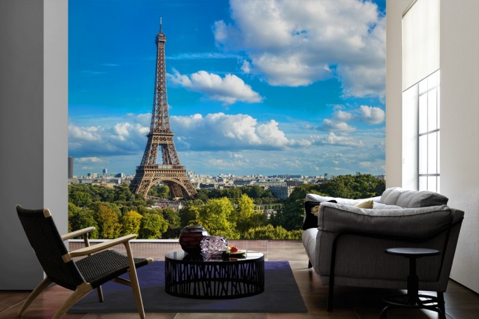 Im Wohnzimmer die Fototapete Paris Panorama mit Eifelturm auf einer großen Wand tapeziert. Die Fototapete Paris Panorama mit Eifelturm ist als Vlies-Fototapete im Wohnzimmer leicht zu tapezieren.