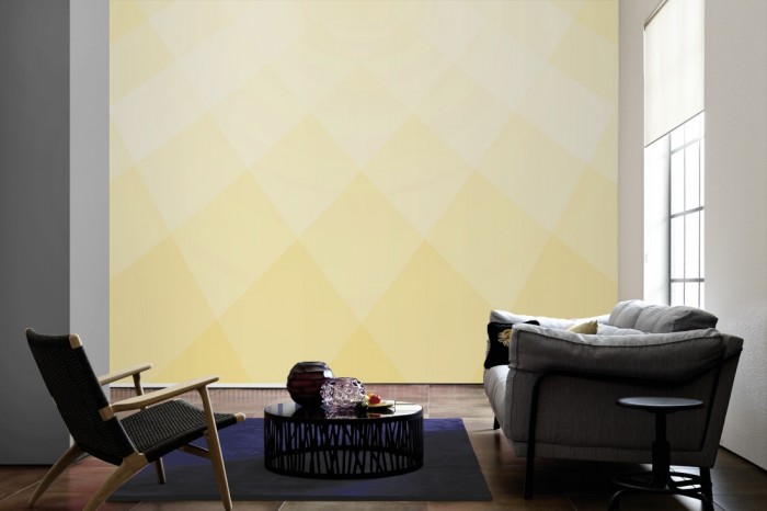 Im Wohnzimmer die Design-Fototapete 3D-Geometrie gelbe Rauten auf einer großen Wand tapeziert. Die Design-Fototapete 3D-Geometrie gelbe Rauten ist als Vlies-Fototapete im Wohnzimmer leicht zu tapezieren.
