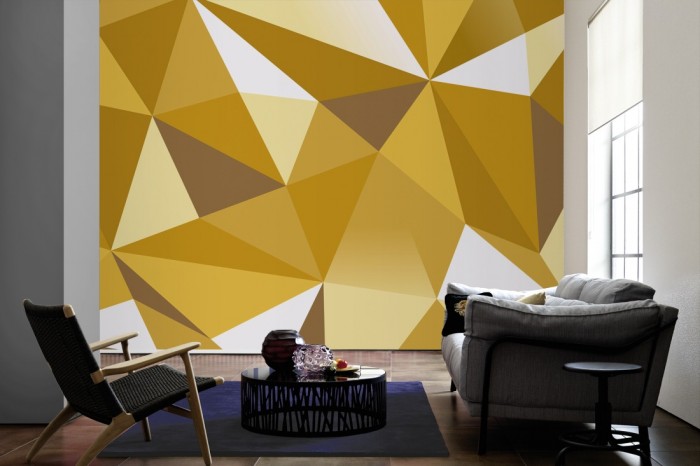 Im Wohnzimmer die Design-Fototapete 3D-Geometrie goldene Dreiecke auf einer großen Wand tapeziert. Die Design-Fototapete 3D-Geometrie goldene Dreiecke ist als Vlies-Fototapete im Wohnzimmer leicht zu tapezieren.