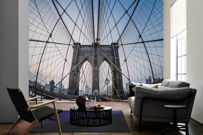 Im Wohnzimmer die Fototapete Brooklyn Bridge in New York, Manhattan auf einer großen Wand tapeziert. Die Fototapete Brooklyn Bridge in New York, Manhattan ist als Vlies-Fototapete im Wohnzimmer leicht zu tapezieren.