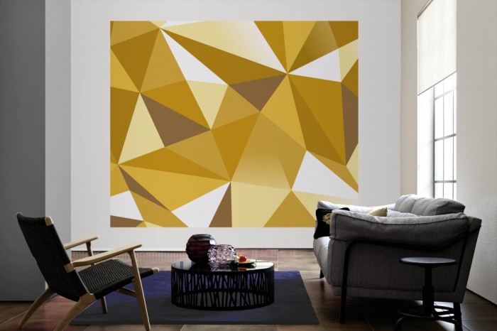 Die Design-Fototapete 3D-Geometrie goldene Dreiecke als große Bildtapete im Wohnzimmer. Als Bildtapete ist die Design-Fototapete 3D-Geometrie goldene Dreiecke ein besonderes Highlight auf Vliestapete.