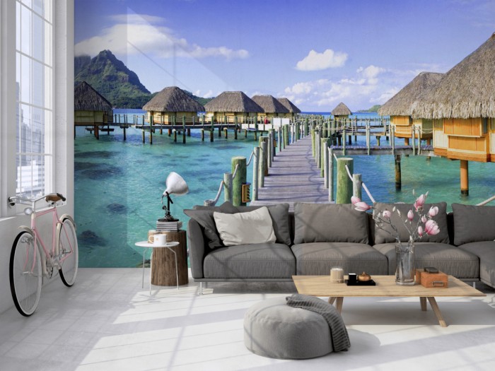 Die Fototapete Tahiti, Häuser im Meer auf einer großen Wand im Loft tapeziert. Die Fototapete Tahiti, Häuser im Meer wird individuell auf Deine Wand angepasst.