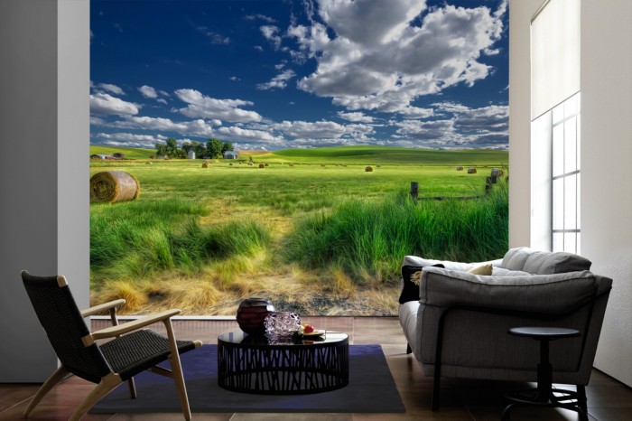 Im Wohnzimmer die Fototapete Landschaft in Amerika mit Strohballen auf einer großen Wand tapeziert. Die Fototapete Landschaft in Amerika mit Strohballen ist als Vlies-Fototapete im Wohnzimmer leicht zu tapezieren.