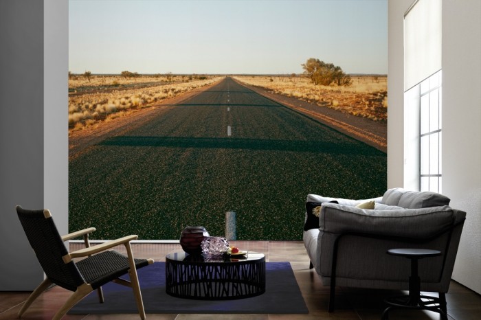 Im Wohnzimmer die Fototapete Strasse durch Australiens Wüste auf einer großen Wand tapeziert. Die Fototapete Strasse durch Australiens Wüste ist als Vlies-Fototapete im Wohnzimmer leicht zu tapezieren.