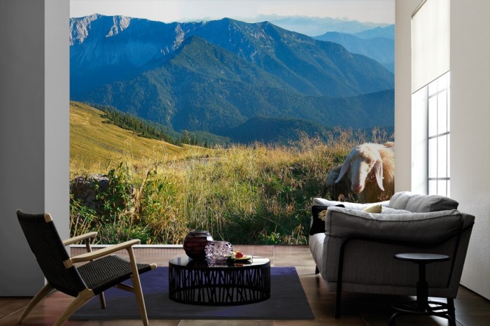 Im Wohnzimmer die Fototapete Bergpanorama in den Alpen auf einer großen Wand tapeziert. Die Fototapete Bergpanorama in den Alpen ist als Vlies-Fototapete im Wohnzimmer leicht zu tapezieren.