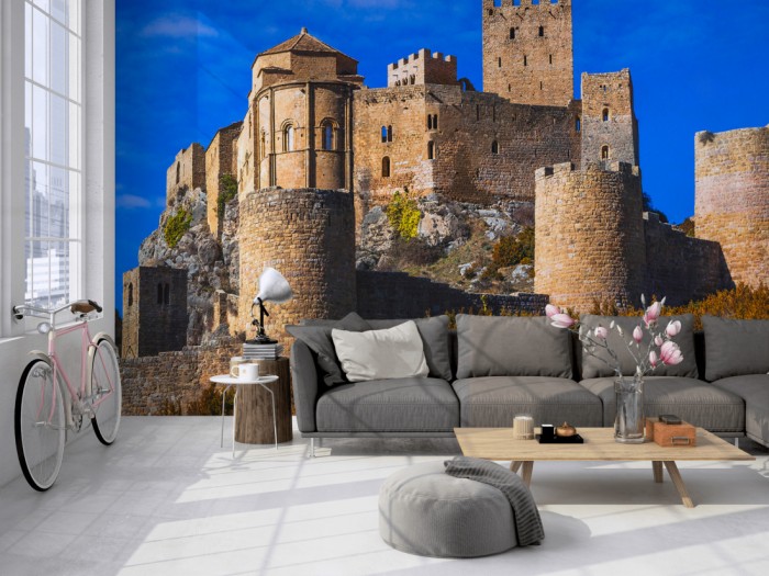 Die Fototapete Burg im Sonnenschein, Castillo de Loarre auf einer großen Wand im Loft tapeziert. Die Fototapete Burg im Sonnenschein, Castillo de Loarre wird individuell auf Deine Wand angepasst.