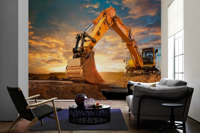 Im Wohnzimmer die Fototapete Gelber Bagger bei Sonnenaufgang auf einer großen Wand tapeziert. Die Fototapete Gelber Bagger bei Sonnenaufgang ist als Vlies-Fototapete im Wohnzimmer leicht zu tapezieren.