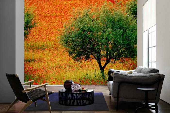 Im Wohnzimmer die Fototapete Mohnblumen Feld mit Baum auf einer großen Wand tapeziert. Die Fototapete Mohnblumen Feld mit Baum ist als Vlies-Fototapete im Wohnzimmer leicht zu tapezieren.