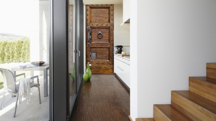 Ein Foto von dem 3D Fotopanel Alte Holztür aus Eiche mit Nieten tapeziert in der Küche. Bestelle Deine Bildtapete online.