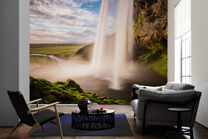 Im Wohnzimmer die Fototapete Wasserfall in Island auf einer großen Wand tapeziert. Die Fototapete Wasserfall in Island ist als Vlies-Fototapete im Wohnzimmer leicht zu tapezieren.