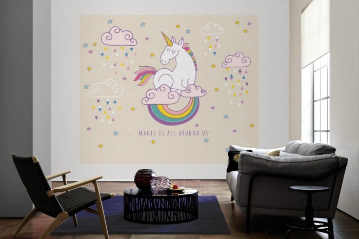 Die Fototapete Einhorn auf rosa Wolken als große Bildtapete im Wohnzimmer. Als Bildtapete ist die Fototapete Einhorn auf rosa Wolken ein besonderes Highlight auf Vliestapete.