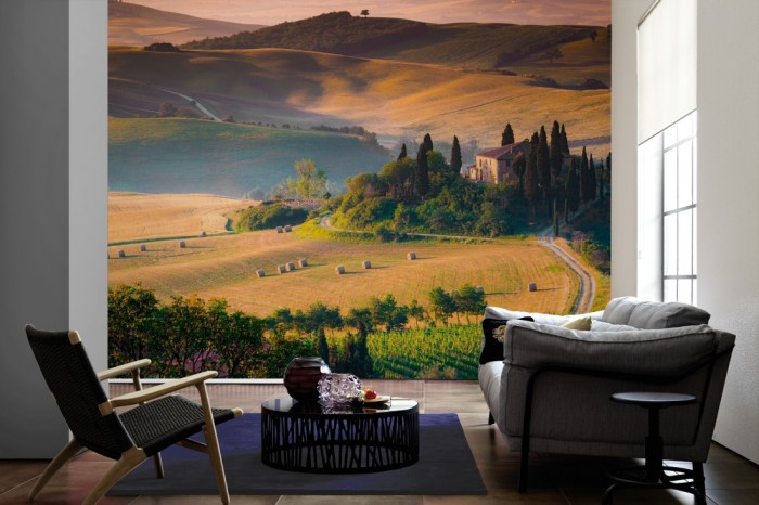 Im Wohnzimmer die Fototapete Toskana bei Sonnenuntergang auf einer großen Wand tapeziert. Die Fototapete Toskana bei Sonnenuntergang ist als Vlies-Fototapete im Wohnzimmer leicht zu tapezieren.