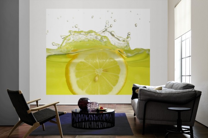 Die Fototapete Zitrone in Limonade als große Bildtapete im Wohnzimmer. Als Bildtapete ist die Fototapete Zitrone in Limonade ein besonderes Highlight auf Vliestapete.