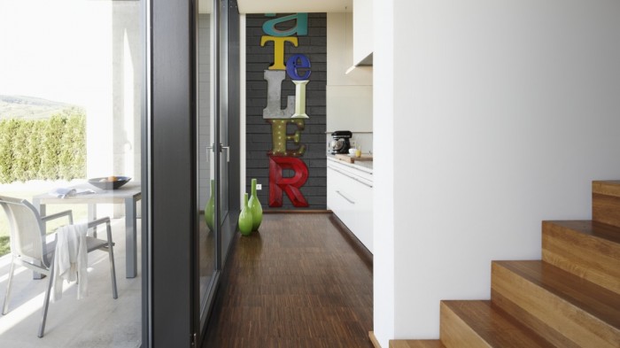 Ein Foto von dem 3D-Fotopanel Schrift ATELIER auf Ziegelstein tapeziert in der Küche. Bestelle Deine Bildtapete online.