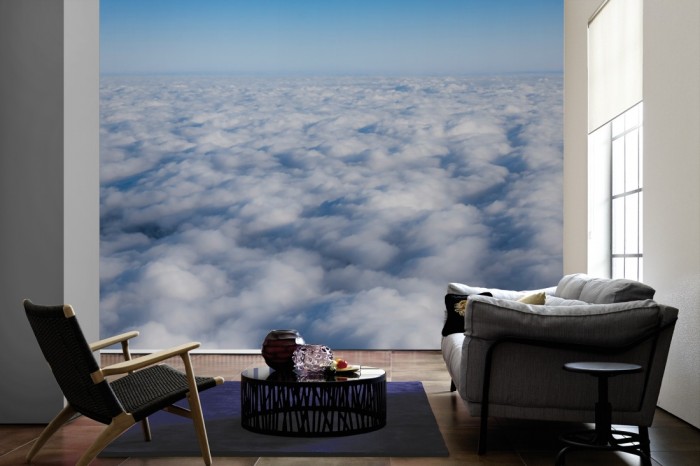 Im Wohnzimmer die Fototapete Über den Wolken 1 auf einer großen Wand tapeziert. Die Fototapete Über den Wolken 1 ist als Vlies-Fototapete im Wohnzimmer leicht zu tapezieren.