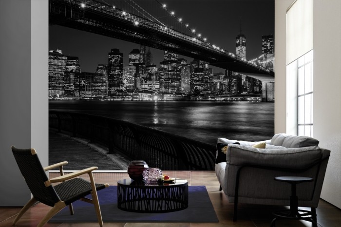 Im Wohnzimmer die Fototapete Manhattan bei Nacht, New York, schwarz-weiß auf einer großen Wand tapeziert. Die Fototapete Manhattan bei Nacht, New York, schwarz-weiß ist als Vlies-Fototapete im Wohnzimmer leicht zu tapezieren.