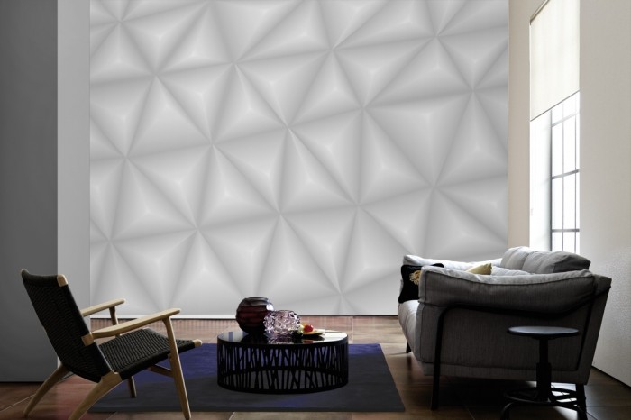 Im Wohnzimmer die Design-Fototapete 3D-Geometrie graue Dreiecke auf einer großen Wand tapeziert. Die Design-Fototapete 3D-Geometrie graue Dreiecke ist als Vlies-Fototapete im Wohnzimmer leicht zu tapezieren.