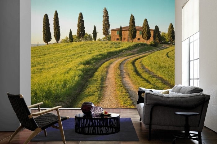 Im Wohnzimmer die Fototapete Toskana Haus im Sommer auf einer großen Wand tapeziert. Die Fototapete Toskana Haus im Sommer ist als Vlies-Fototapete im Wohnzimmer leicht zu tapezieren.