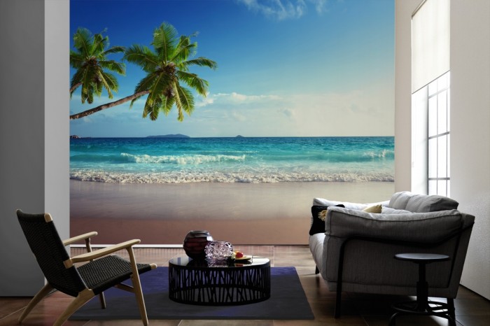 Im Wohnzimmer die Fototapete Strand mit Palmen auf den Seychellen auf einer großen Wand tapeziert. Die Fototapete Strand mit Palmen auf den Seychellen ist als Vlies-Fototapete im Wohnzimmer leicht zu tapezieren.