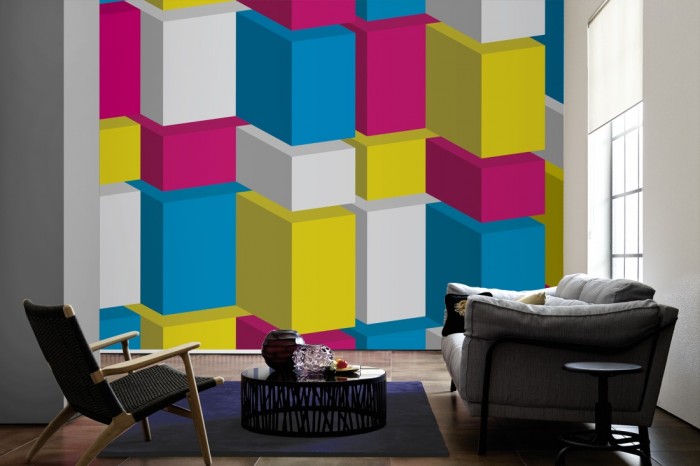 Im Wohnzimmer die Design-Fototapete 3D-Geometrie bunte Rechtecke auf einer großen Wand tapeziert. Die Design-Fototapete 3D-Geometrie bunte Rechtecke ist als Vlies-Fototapete im Wohnzimmer leicht zu tapezieren.