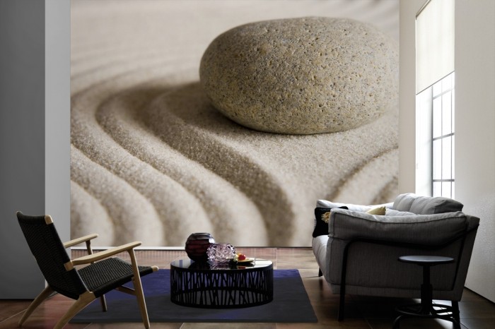 Im Wohnzimmer die Fototapete Stein im Sand auf einer großen Wand tapeziert. Die Fototapete Stein im Sand ist als Vlies-Fototapete im Wohnzimmer leicht zu tapezieren.