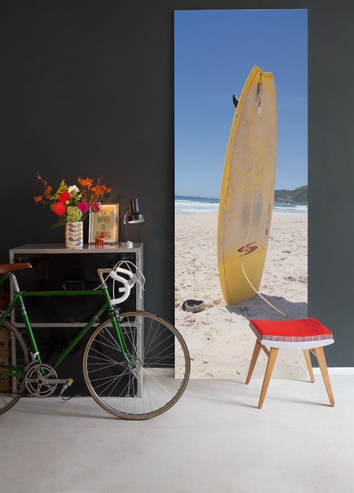 Ein Foto von dem 3D-Fotopanel Surfbrett am Strand von Hawaii tapeziert im Raum. Bestelle Deine Bildtapete online.